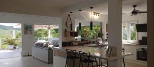 a kitchen and living room with a table and chairs at La Maison Bwa in Les Trois-Îlets