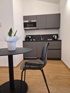 a black chair sitting next to a table in a kitchen at Mediterranea Apartments Sunrise in Assemini +3 photos