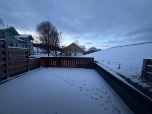 a snow covered backyard with footprints in the snow at Panorama Apartments II in Lohberg
