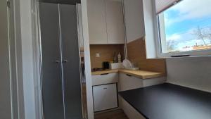 a small kitchen with white cabinets and a window at Mini nocleg przy dworcu in Tomaszów Mazowiecki