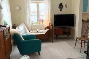 a living room with a tv and a couch and a chair at Steinbakk - Vestresand Lofoten in Bøstad
