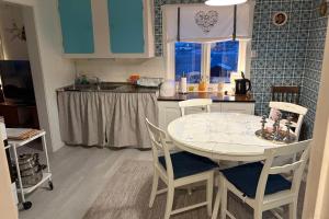 a kitchen with a table and chairs in a kitchen at Steinbakk - Vestresand Lofoten in Bøstad +25 photos