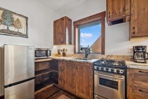 a kitchen with wooden cabinets and a stainless steel refrigerator at Bliss Retreat in Whitefish