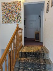 a hallway with stairs with a painting on the wall at Ferienhaus "Fritz" mit 3 Schlafzimmern in Seenähe in Löbnitz +24 photos