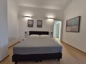 a bedroom with a large bed in a white room at Mediterranea Apartments Aurora in Assemini +10 photos
