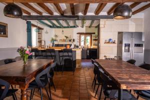 a kitchen and dining room with wooden tables and chairs at B&B BienViennue in Marcilly-sur-Vienne