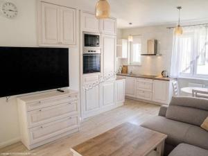 a large white kitchen with a large flat screen tv at Szyper 2 in Jastarnia