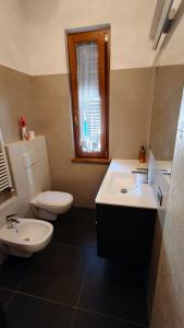 a bathroom with two sinks and a toilet and a window at Casa di Cecco in Stazione di Laterina