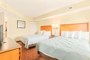 a hotel room with two beds and a television at Bay View Resort 1202 in Myrtle Beach +19 photos