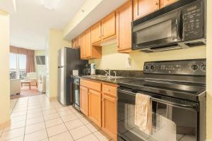 a kitchen with wooden cabinets and a black appliances at Bay View Resort 1202 in Myrtle Beach