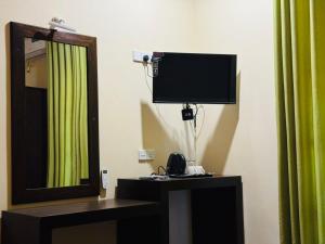 a room with a mirror and a tv on the wall at NILGIRA VILLA By LILYS in Badulla +17 photos
