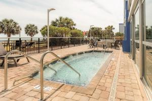 a swimming pool in a patio with chairs and tables at Bay View Resort 1202 in Myrtle Beach