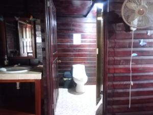 a bathroom with a toilet and a sink and a fan at Cabañas El Cuyo in El Cuyo