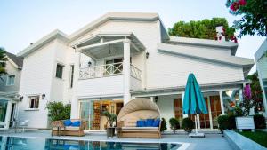 a white house with a swimming pool and an umbrella at Villa No 44 in Darıca