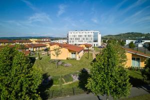 Luftaufnahme einer Stadt mit einem großen weißen Gebäude in der Unterkunft VOYA Hotel in Ringsheim