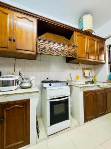 a kitchen with a white stove and wooden cabinets at Green House DHK in Dhaka