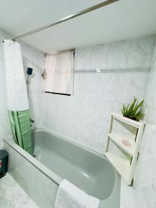 a white bathroom with a tub and a mirror at Green House DHK in Dhaka +45 photos
