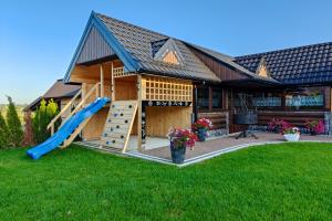 a play house with a slide in the yard at Willa Bustryk in Bustryk