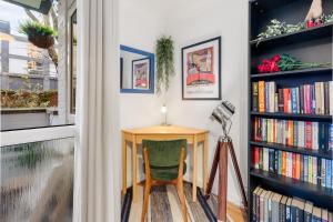 a desk with a green chair next to a book shelf at Stylish 2 bed Central London in London