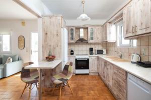 a kitchen with wooden cabinets and a table and chairs at Villa Anastasis in Halikounas