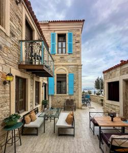a patio with tables and chairs in front of a building at Marina Foça Hotel in Foça