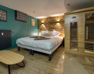 a bedroom with a large bed and a table at La Parenthèse in Compiègne