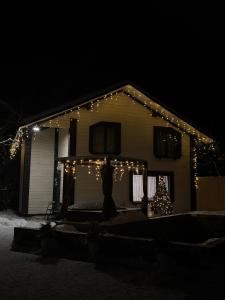 a house with christmas lights and a christmas tree on it at Гія в Баню in Mizhhirya