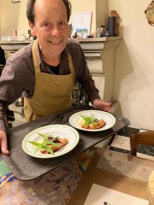 a man holding a tray with two plates of food at Belle de Nuit in Oppède
