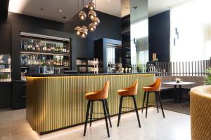 a bar with orange stools in a restaurant at Pannonia Tower in Parndorf