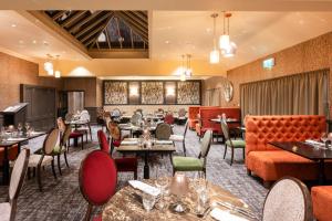 a restaurant with tables and chairs and couches at Park Farm Hotel in Norwich