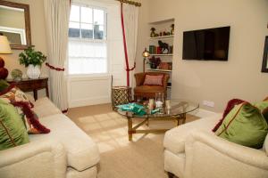 a living room with two couches and a tv at Wilson House in St. Andrews
