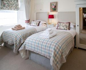 a bedroom with two beds with towels on them at Wilson House in St. Andrews