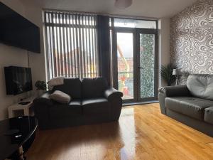 a living room with a couch and a couch and a tv at 2 Bedroom Apartment - Henry St Central Liverpool in Liverpool