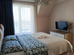 a bedroom with a bed and a tv and a window at AMAYA in Varna City