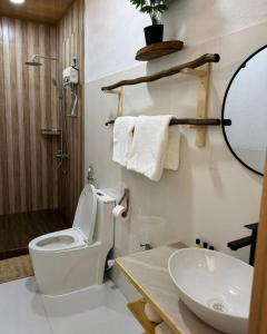 a bathroom with a toilet and a sink and a mirror at Coral stone in Bileffahi