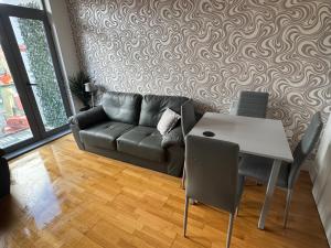 a living room with a couch and a table at 2 Bedroom Apartment - Henry St Central Liverpool in Liverpool
