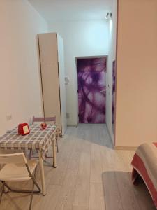 a room with a table and chairs and a purple door at La Rosa di Orvieto in Orvieto