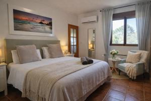 a bedroom with a large bed and a chair at Wonderful Villa, Heated Pool, Near Beautiful Xàtiva Town in Alboy