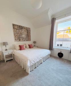 a white bedroom with a bed and a window at Ard Solas in Crieff