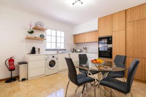 a kitchen with a glass table and chairs in a kitchen at Casa Flor do Campo in Calheta