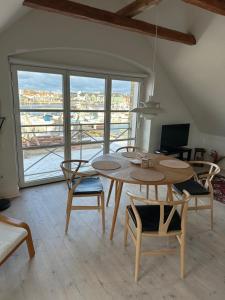 a table and chairs in a room with a large window at Havnehuset Kerteminde in Kerteminde
