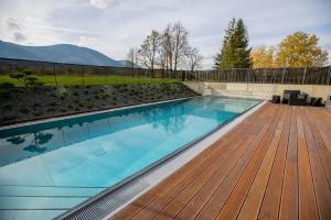 a swimming pool with a wooden deck and a swimming pool at Miura Hotel in Čeladná