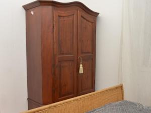 a wooden cabinet in a bedroom with a bed at Central apartment in Arluno