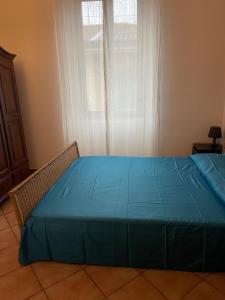 a bedroom with a blue bed in front of a window at Central apartment in Arluno