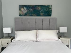 a bedroom with a bed with two nightstands and two lamps at Ard Solas in Crieff