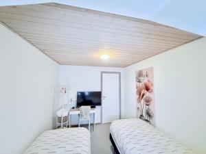a white room with two beds and a desk at OJ Home in Vojens +27 photos