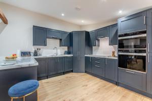 a kitchen with blue cabinets and a blue stool at 2 Bed in Latton oc-c34099 in Clapton +15 photos
