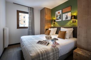 a hotel room with a bed with a book on it at Résidence Club MMV SERRE CHEVALIER Le Serra Neva in La Salle-les-Alpes +47 photos