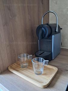 two glasses on a cutting board next to a toaster at Gîte Du Côté de Chez Souesmes in Souesmes