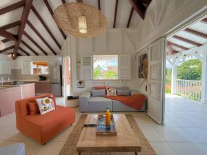 a living room with a couch and a table at Villa Altaïa - Sea View & Infinity Pool in Les Trois-Îlets